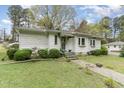 View of a charming single-story home featuring a welcoming front yard with mature landscaping at 201 E End Ave, Durham, NC 27703