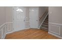 Inviting foyer with hardwood floors, classic wainscoting, and a staircase leading to the upper level at 203 Grassy Point Rd, Apex, NC 27502