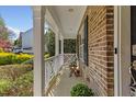 Charming brick home featuring a welcoming front porch, perfect for relaxing and enjoying the outdoors at 219 Arbordale Ct, Cary, NC 27518