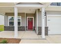 Inviting front porch with white columns, leading to a red front door and a two-car garage at 2202 Cherry Creek Rd, Haw River, NC 27258