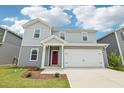 Charming two-story home featuring gray siding, a red front door, an attached garage, and landscaped front yard at 2206 Cherry Creek Rd, Haw River, NC 27258