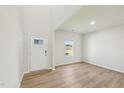 Bright entryway features a high ceiling, wood-look floors, and a modern white front door with sidelight at 2210 Cherry Creek Rd, Haw River, NC 27258