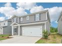 Two-story home featuring gray siding, a two-car garage and a covered front porch at 2210 Cherry Creek Rd, Haw River, NC 27258