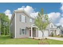Two-story home featuring gray siding, a two-car garage and a covered front porch at 2210 Cherry Creek Rd, Haw River, NC 27258