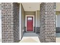 Covered entrance with brick columns, red front door with glass pane, and light gray siding at 2211 Cherry Creek Rd, Haw River, NC 27258