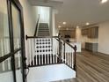 Inviting entryway with staircase and view of the modern kitchen and light wood flooring at 2401 Whitewing Ln, Wendell, NC 27591