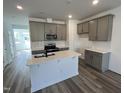Modern kitchen featuring gray cabinets, a white island, stainless steel appliances and stylish backsplash at 2401 Whitewing Ln, Wendell, NC 27591
