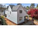View of a charming two-story home featuring light-colored siding, black trim windows, and an inviting covered entryway at 2605 Hazelwood Dr, Raleigh, NC 27608