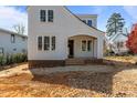 Charming two-story home featuring light-colored siding, black trim windows, and an inviting covered entryway at 2605 Hazelwood Dr, Raleigh, NC 27608