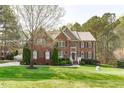Attractive two-story brick home with a well-manicured lawn and mature trees at 2909 Timpani Trl, Apex, NC 27539