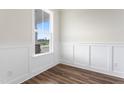 Bright room featuring luxury vinyl plank flooring, a window, and white wainscotting at 304 Catheys Creek Cir, Wendell, NC 27591