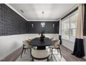 Well-lit dining room featuring an elegant light fixture, modern wallpaper, and seating for six at 3914 Glorybower Way, Apex, NC 27502