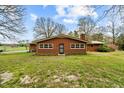 Brick home in a large backyard, complemented by mature trees and greenery at 4018 Moon Lindley Rd, Snow Camp, NC 27349