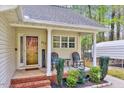 Close up of a cozy front porch with seating, brick steps, and a welcoming entrance to the home at 413 Correy Pl, Clayton, NC 27520