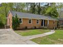 Angle view of a brick home featuring a well-maintained yard and classic architectural details at 4815 Oak Park Rd, Raleigh, NC 27612