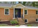 Inviting front entrance showcasing a brick facade, stylish front door, and manicured landscaping at 4815 Oak Park Rd, Raleigh, NC 27612