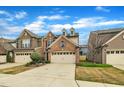 Attractive townhome with a mix of brick and siding, complete with a two-car garage and green lawn at 520 Brier Crossings Loop, Durham, NC 27703