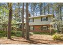 Inviting brick home featuring a mix of siding and brick facade with mature trees and landscaping at 704 Emory Dr, Chapel Hill, NC 27517