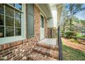 Close up shot of a brick home featuring an entrance area with steps, railings, and window at 704 Emory Dr, Chapel Hill, NC 27517
