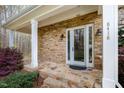 Inviting front porch with stone accents and a stylish entrance door, creating a warm and welcoming first impression at 8418 Wheatstone Ln, Raleigh, NC 27613