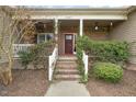 Close-up of the inviting front porch with brick steps and decorative greenery at 8437 Little Woody Ct, Zebulon, NC 27597