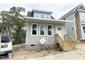 Charming gray home with bright windows and inviting entryway with wood stairs at 905 Linwood Ave, Durham, NC 27701