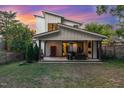 A covered patio with an outdoor seating area, a fireplace, and a lush green backyard at sunset at 915 S State St, Raleigh, NC 27601