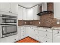 Modern kitchen with stainless steel appliances, custom white cabinets, and a stylish backsplash creating a gourmet cooking space at 97 Bailey Rd, Coats, NC 27521