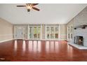 Spacious living room with hardwood floors, a charming fireplace, and ample natural light flooding through large windows at 97 Bailey Rd, Coats, NC 27521