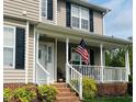 Inviting front porch with white railings, brick steps, and patriotic American flag at 10 Sapphire Dr, Sanford, NC 27332
