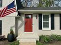 Close-up of the front door with a red finish, black shutters, and decorative potted plants at 1100 Medlin Dr, Cary, NC 27511