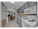Functional kitchen features grey cabinets, tile backsplash, and essential appliances at 120 Schultz St, Chapel Hill, NC 27514