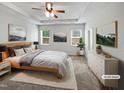This bedroom features a tray ceiling, neutral walls, windows, and ceiling fan, providing a serene retreat at 1206 Kafka Dr, Fuquay Varina, NC 27526