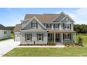 Charming two-story home with gray siding, brown shutters, and a pristine green lawn on a sunny day at 125 Summerlin Dr, Clayton, NC 27527