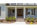 Inviting front porch with stone steps, manicured shrubs, and a stylish wooden double door entrance at 125 Summerlin Dr, Clayton, NC 27527