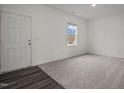Bright carpeted bedroom with a white door and window providing ample natural light at 128 N Keatts Winner Ct, Clayton, NC 27520