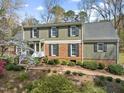 Charming two-story home with brick and siding, black shutters, and a beautifully landscaped front yard at 1302 Hermitage Rd, Sanford, NC 27330