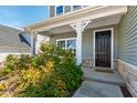Inviting front porch with a black front door, decorative plants, and stone accents enhancing curb appeal at 139 Pronghorn Deer Ct, Garner, NC 27529