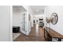 Bright hallway featuring hardwood floors, stylish decor, and an open view into the living room and kitchen at 139 Pronghorn Deer Ct, Garner, NC 27529
