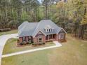 Aerial view of a beautiful brick home featuring well-maintained landscaping and a long driveway at 15101 Aiken Rd, Wake Forest, NC 27587