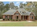 Beautiful brick home with dormers, manicured landscaping, and inviting front porch at 15101 Aiken Rd, Wake Forest, NC 27587