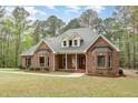 Inviting brick home with a well-manicured lawn, complemented by dormer windows and classic architectural design at 15101 Aiken Rd, Wake Forest, NC 27587