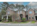 Beautiful brick townhomes featuring sidewalks, manicured lawns, awnings and well-kept landscaping at 1523 Yarborough Park Drive, Raleigh, NC 27604
