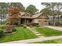Charming brick and stone home with a well-maintained lawn, inviting porch, and mature landscaping at 1525 Marshall Farm St, Wake Forest, NC 27587