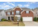 Charming two-story brick home with a well-manicured lawn and attached two-car garage at 1607 Willowcrest Rd, Durham, NC 27703
