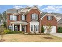 Beautiful brick home featuring a welcoming front porch and well-maintained landscaping at 1607 Willowcrest Rd, Durham, NC 27703
