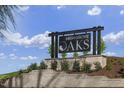 High Grove Oaks entrance sign surrounded by lush landscaping and a retaining wall under a blue sky at 1904 Harrell Cove Ct # 173 Eldorado Cl, Fuquay Varina, NC 27526