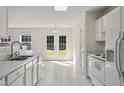 Bright kitchen with white cabinets, stainless steel appliances, and views to the backyard at 1905 Maple Sugar Ln, Fuquay Varina, NC 27526