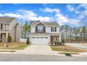 Charming two-story home with gray siding, stone accents, and a two-car garage at 211 Azalea Gaze Dr, Youngsville, NC 27596