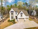 Aerial view of a home with a large driveway, brick facade, and surrounding green landscape at 215 Bonterra Way, Chapel Hill, NC 27516